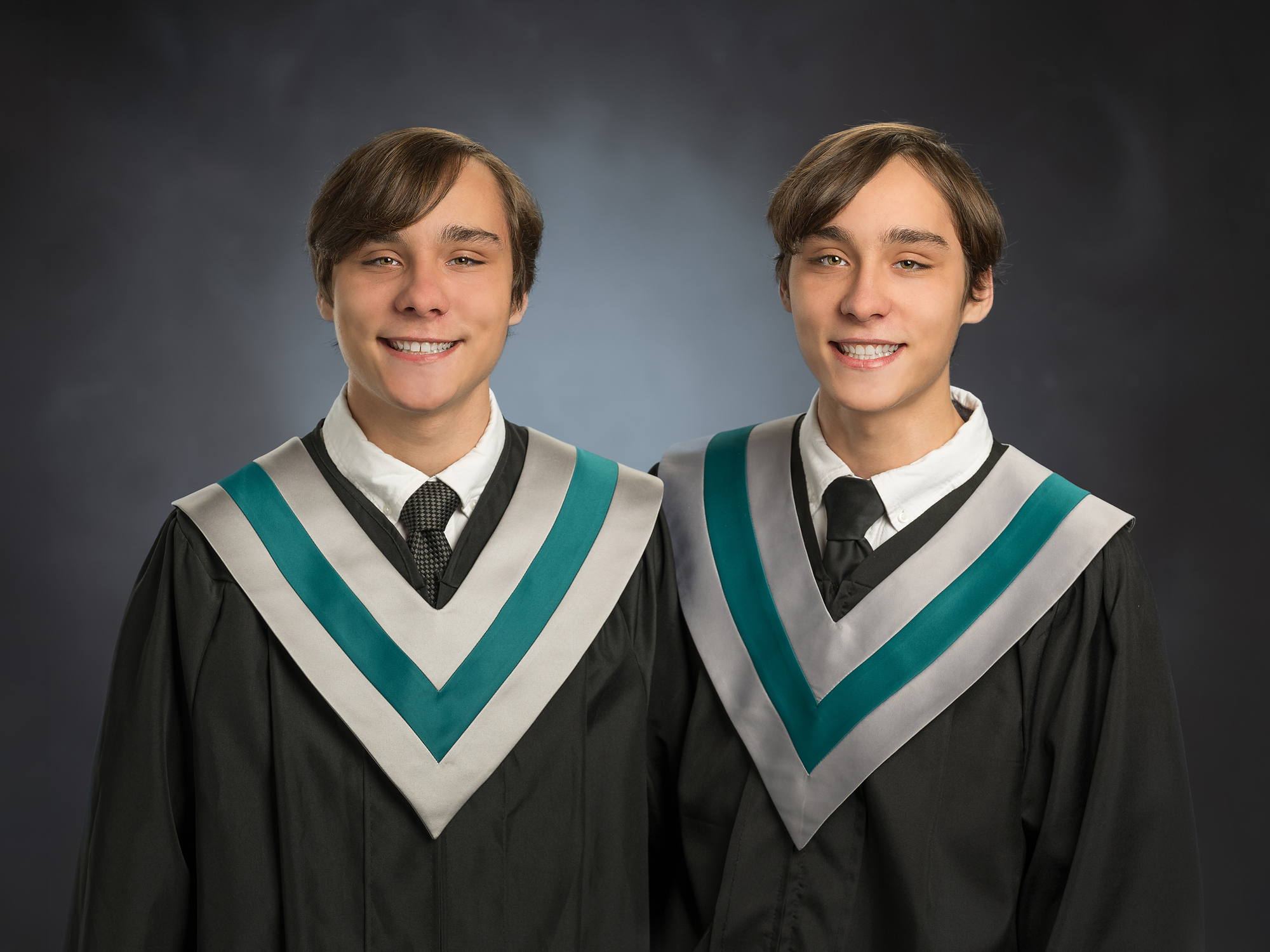 Twin brothers graduating together in black gowns with teal sashes, Grad Plus session