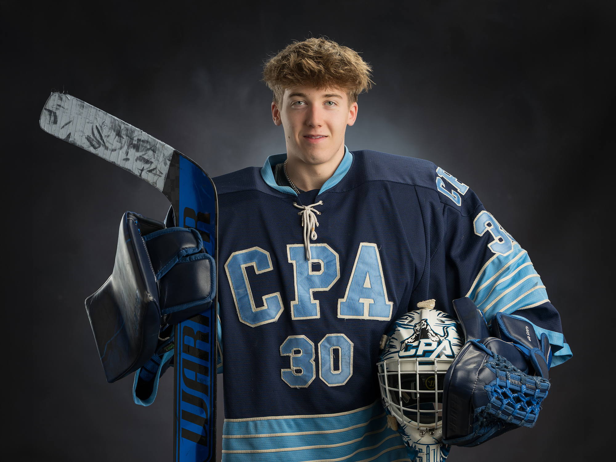 Grad in his CPA hockey goalie jersey with stick, mask and glove, Grad Plus sports gear photo