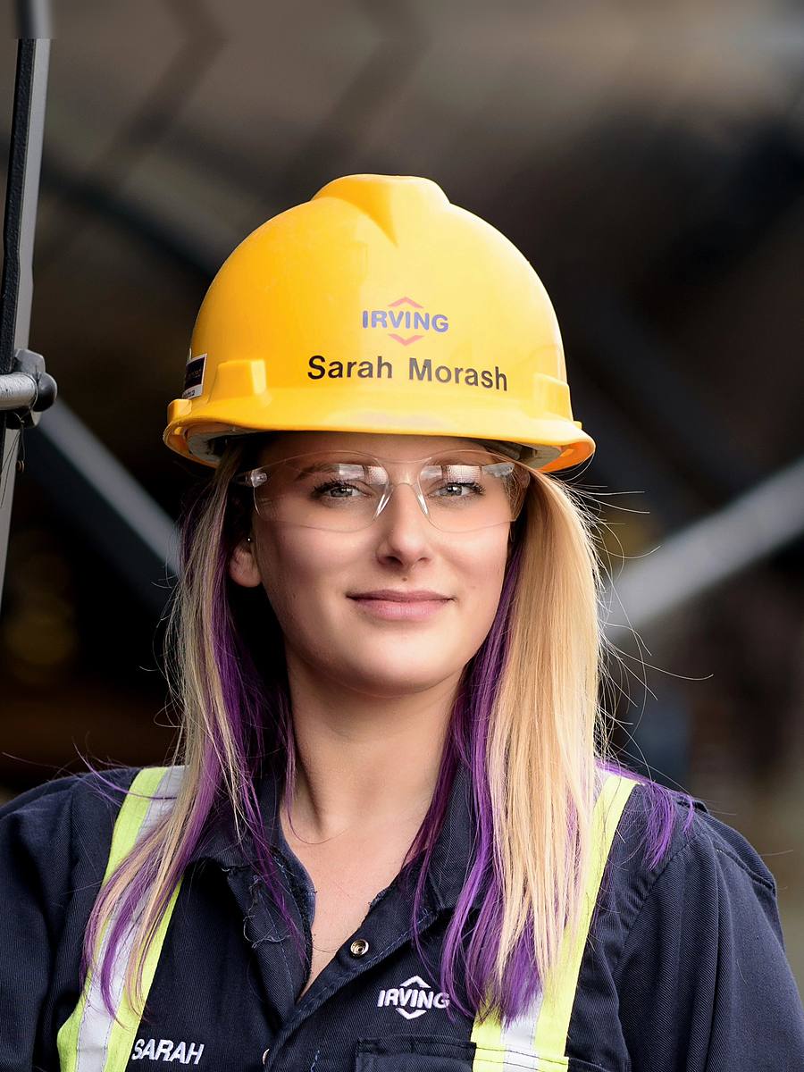 Environmental headshot of Irving Oil's Sarah Morash in a yellow hard hat and safety glasses on site