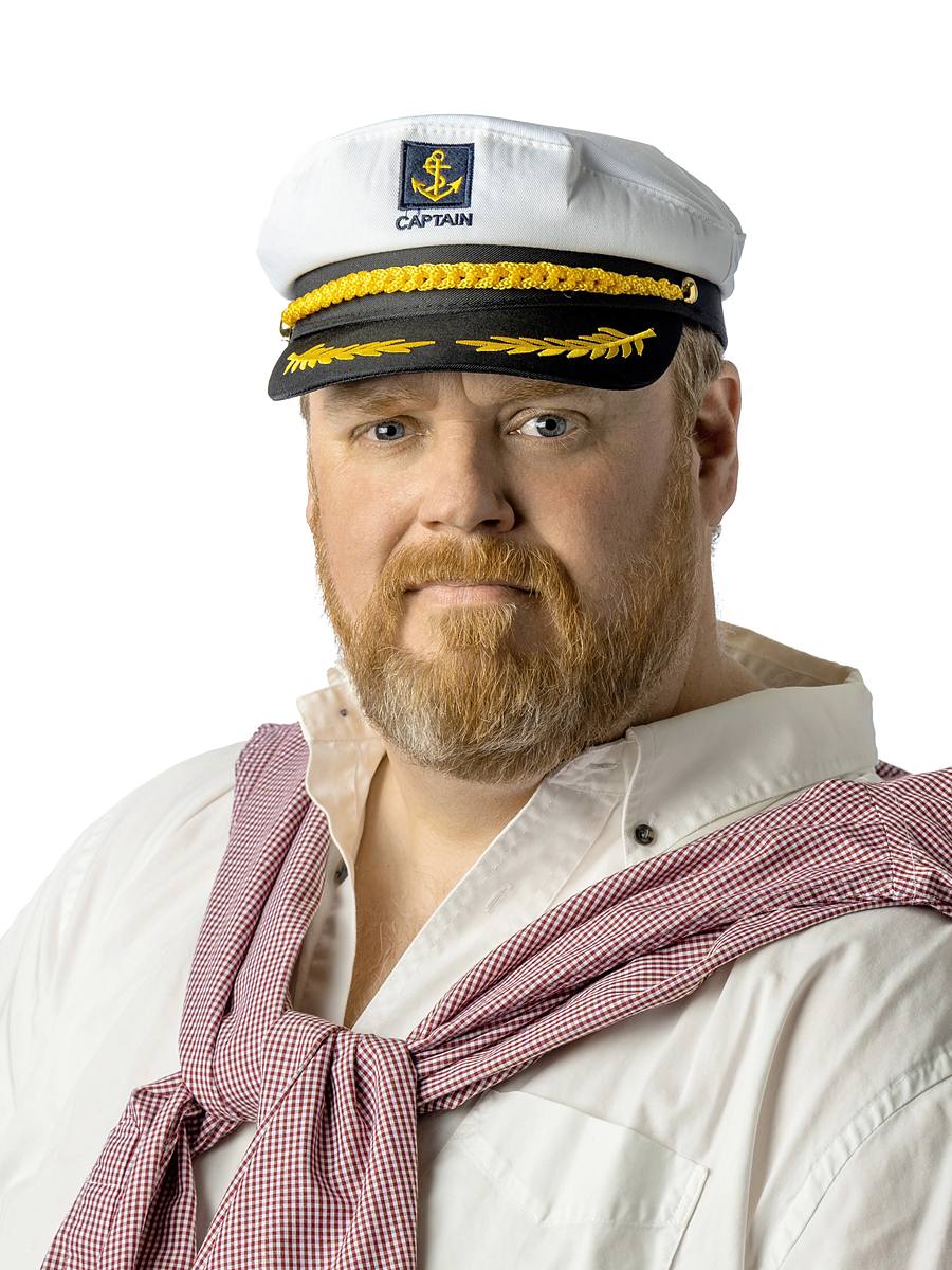 Character headshot of musician Bruce Fillmore in a captain's hat with a gingham shirt tied over his shoulders, Halifax studio