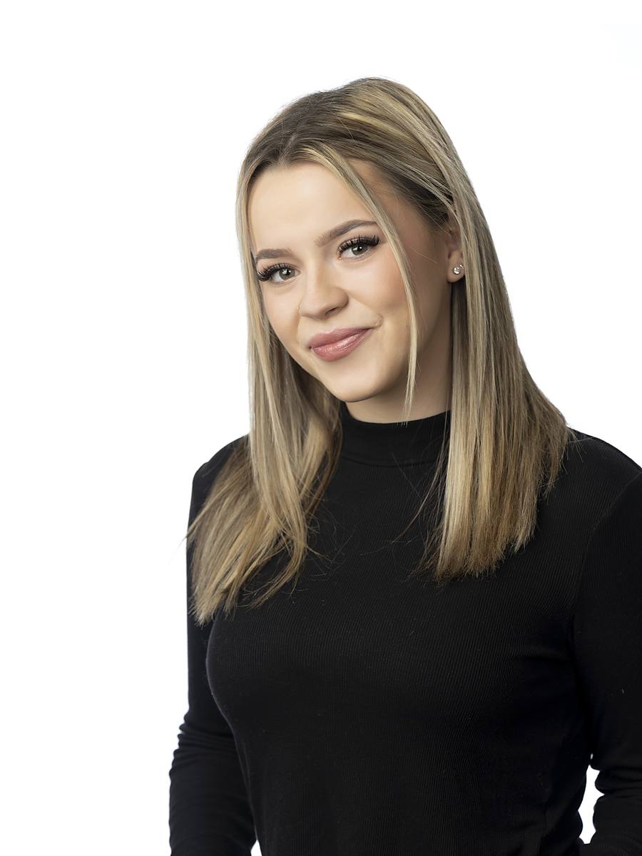 Headshot of Halifax radio host Carlie B in a black turtleneck, studio portrait on white