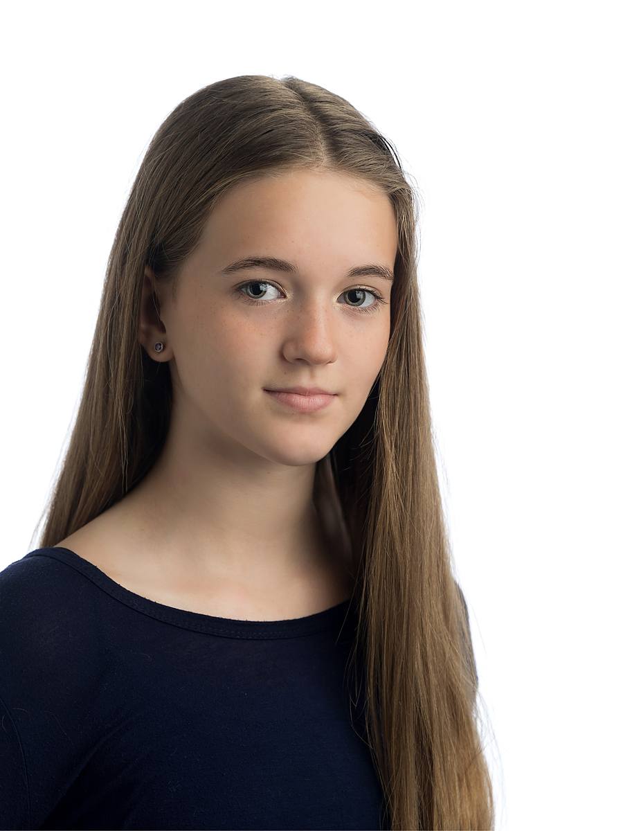 Natural-light style actor headshot of a young performer with long hair in a navy top, Nova Scotia studio