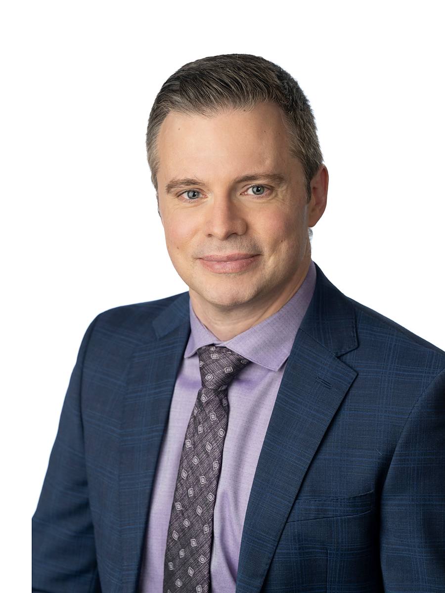 Headshot of CTV Atlantic chief meteorologist Kalin Mitchell in a blue plaid suit, Halifax studio portrait
