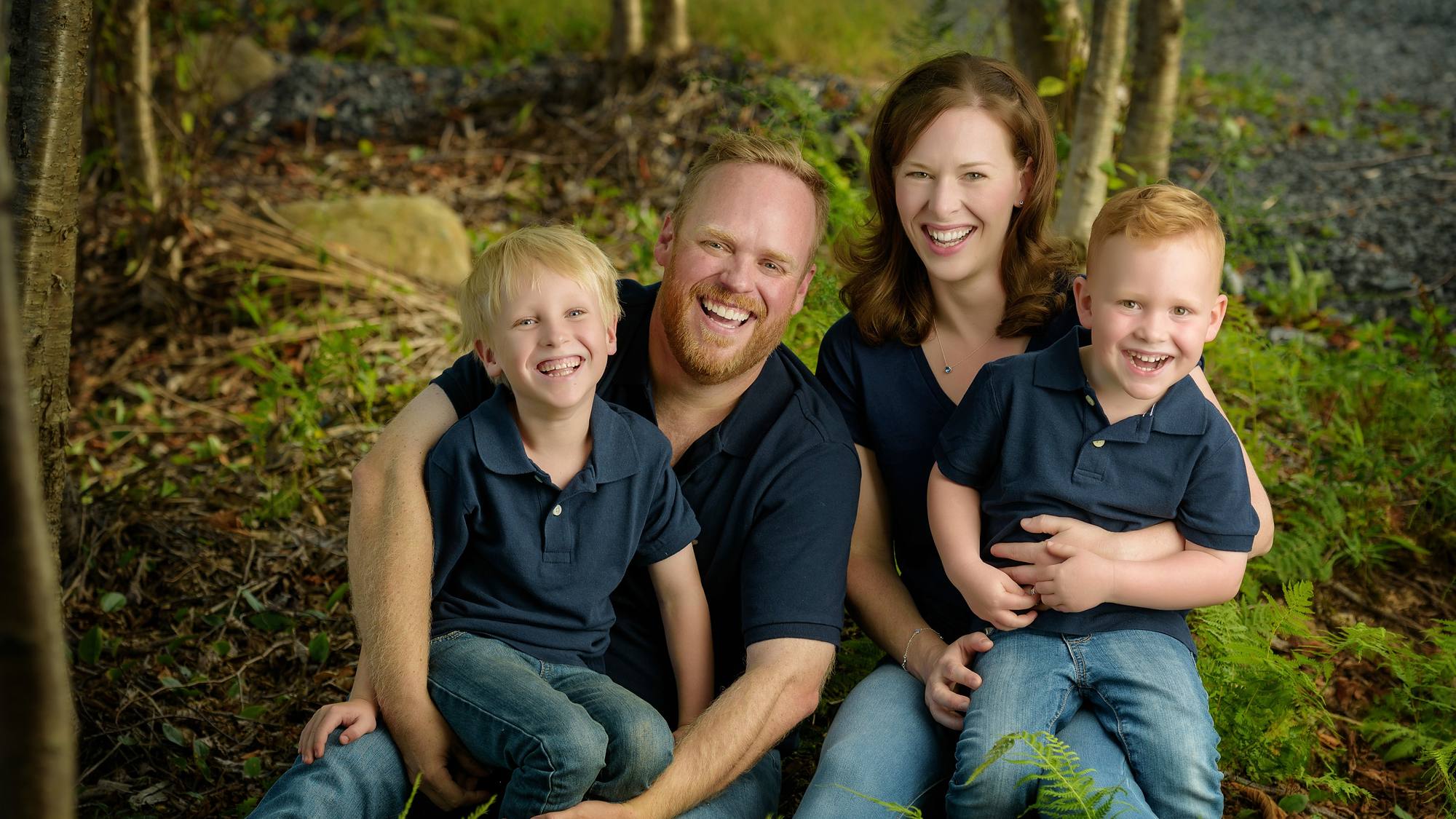 Family of four with two young boys among ferns and birch trees - Nova Scotia family session