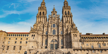 Baroque facade of the Cathedral of Santiago de Compostela under a blue sky.
