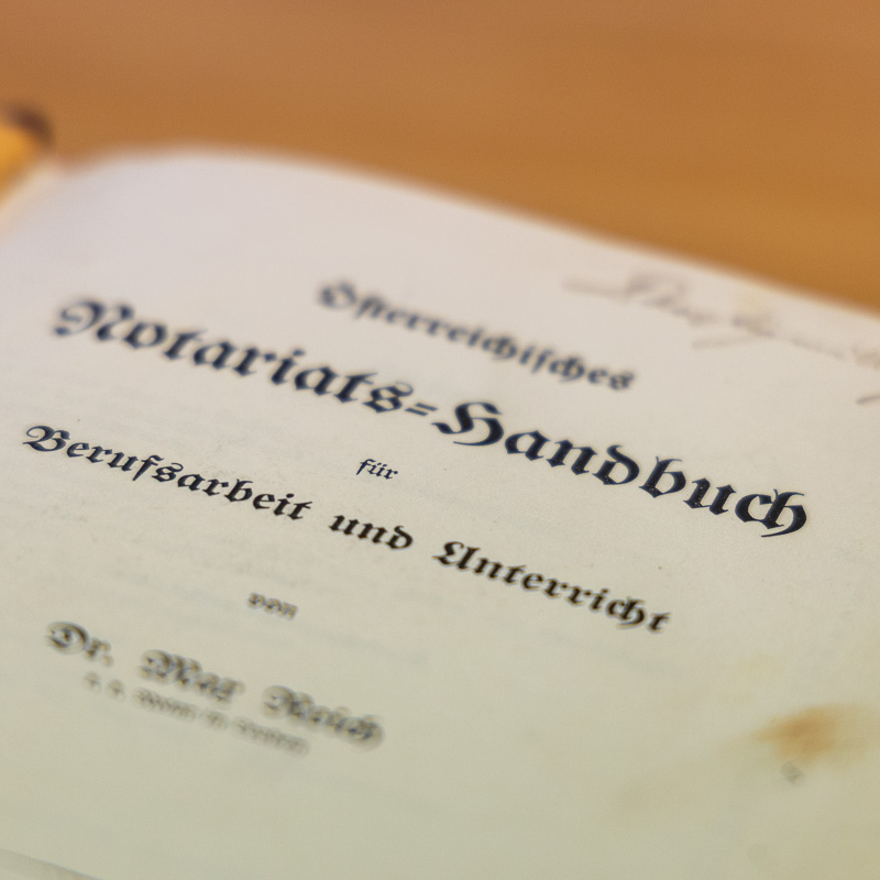 Detailansicht des Titels 'Österreichisches Notariats-Handbuch' von Dr. Max Reich in Frakturschrift in schräger Ansicht