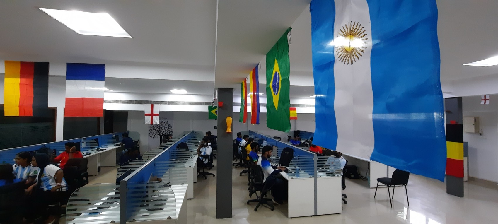 The office floor with national flags of Argentina, Brazil, Germany and others strung along the ceiling above the desks