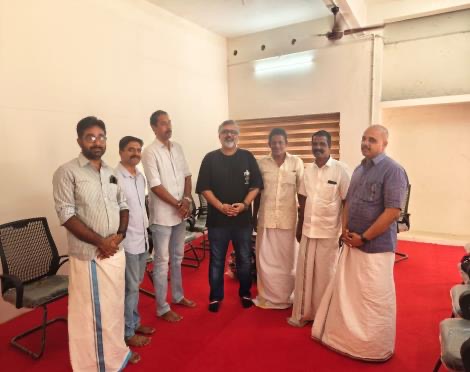 Seven men standing together in the school hall after the handover
