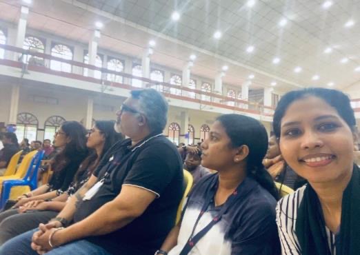 Focaloid colleagues seated among the audience in a large hall, waiting for the programme to begin