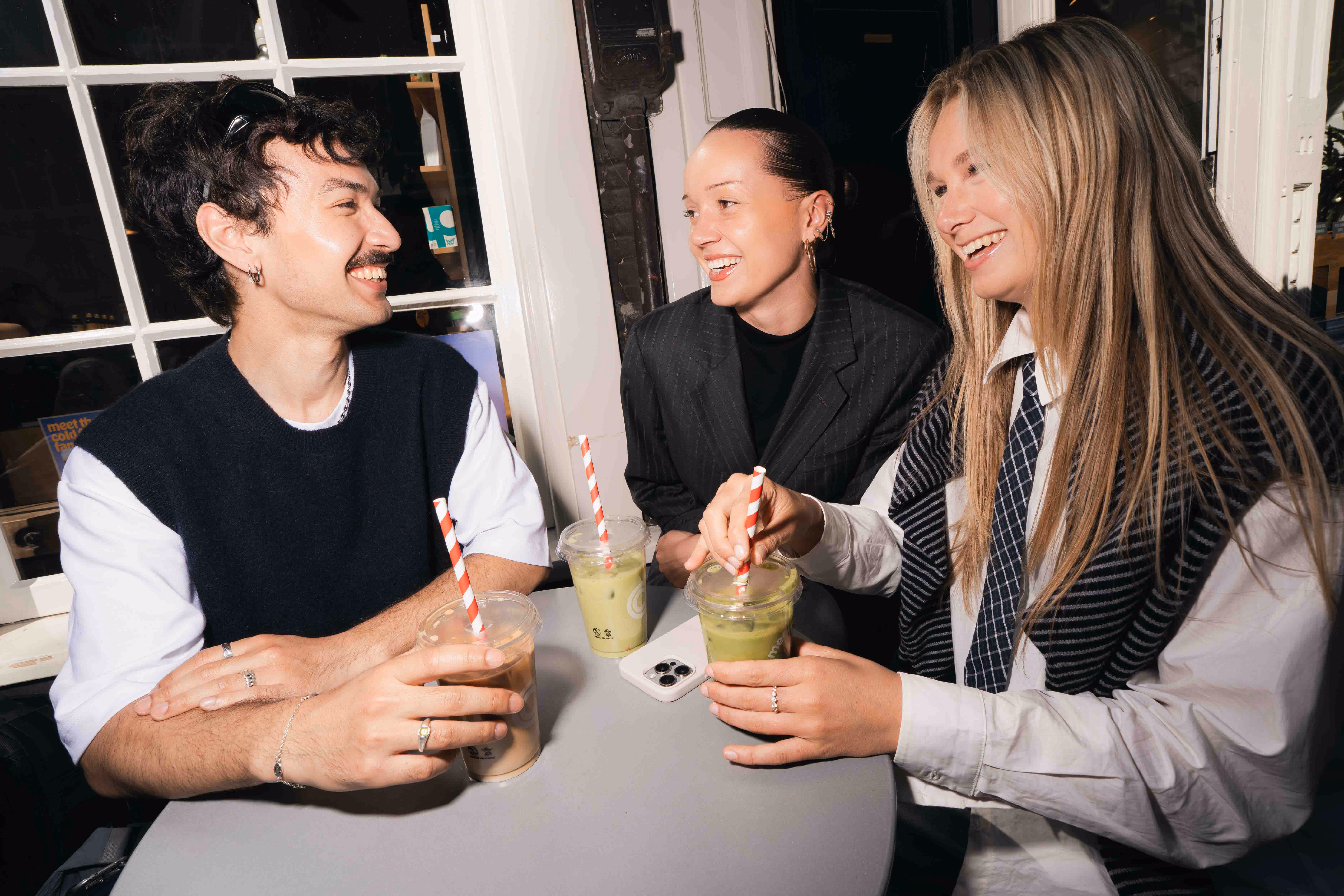 Drie studenten in gesprek aan een tafel
