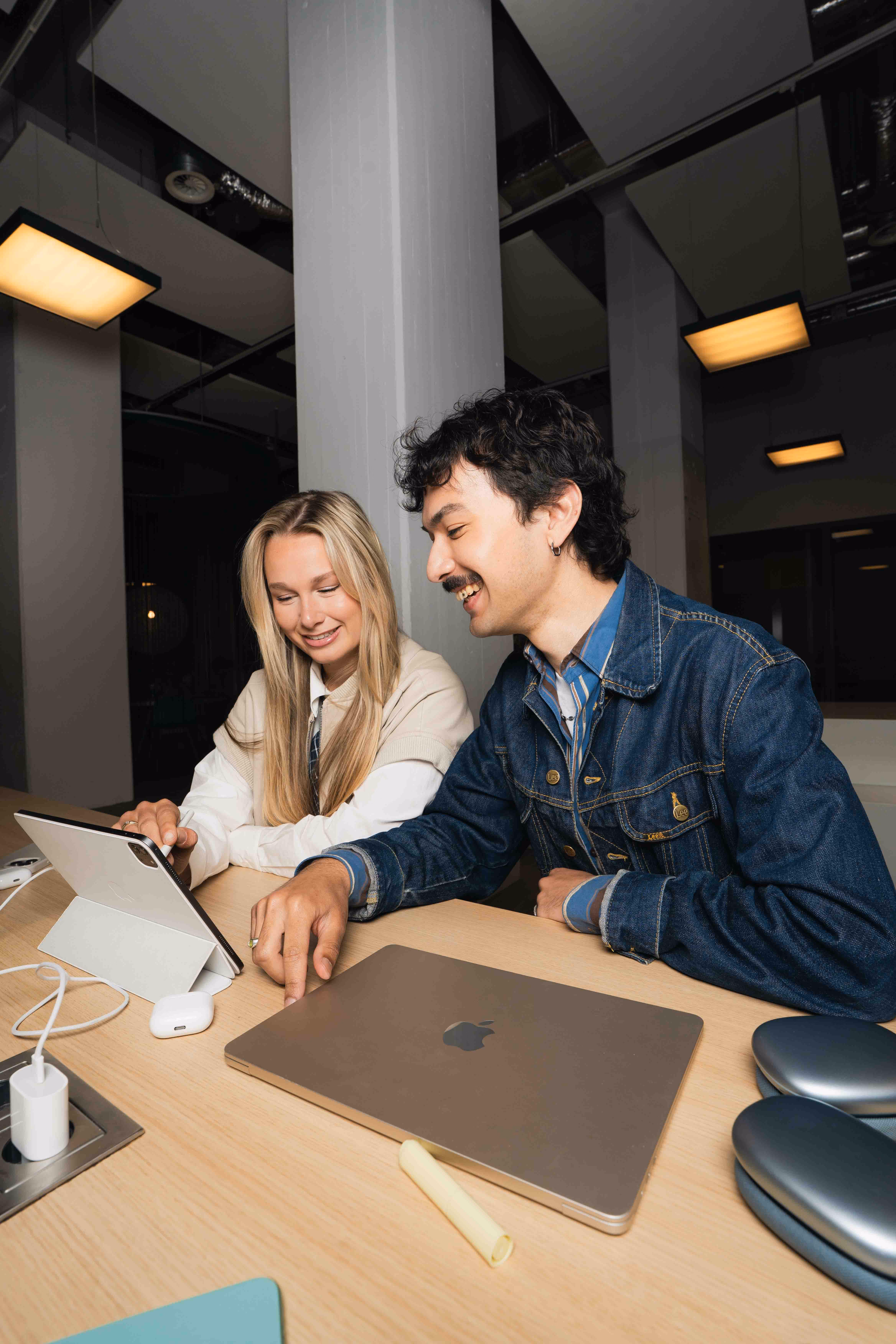 Twee collega's overleggen achter een laptop