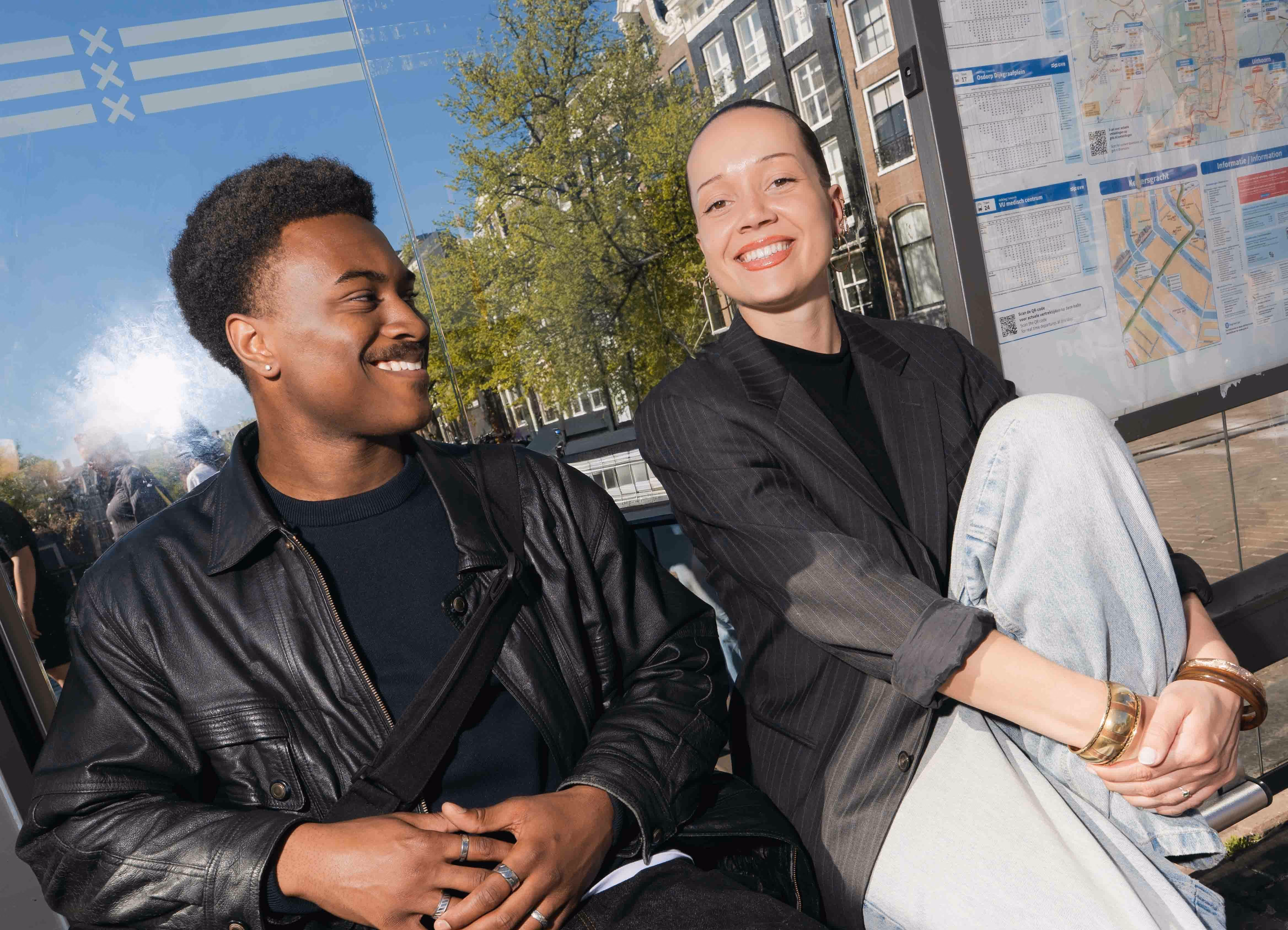 Twee lachende studenten op een bankje in de stad