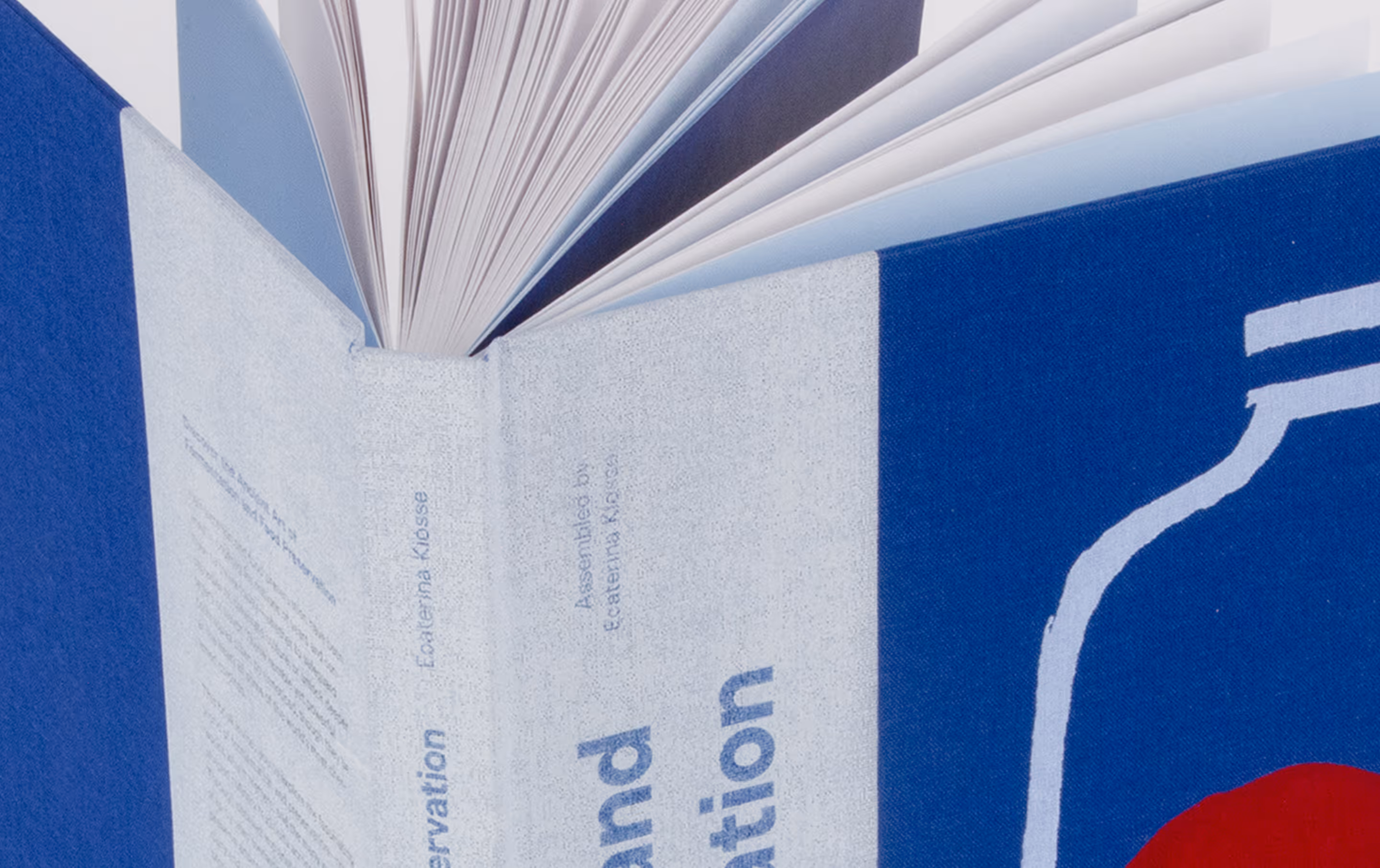 Close-up of an open book with a blue and white cover featuring text and design elements.