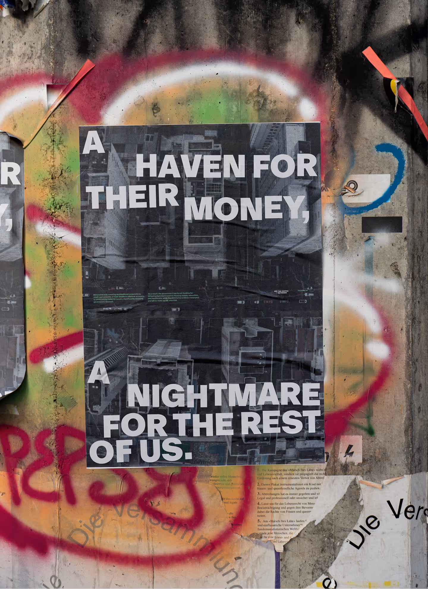 Poster on a graffiti wall reads: 'A haven for their money, a nightmare for the rest of us.'