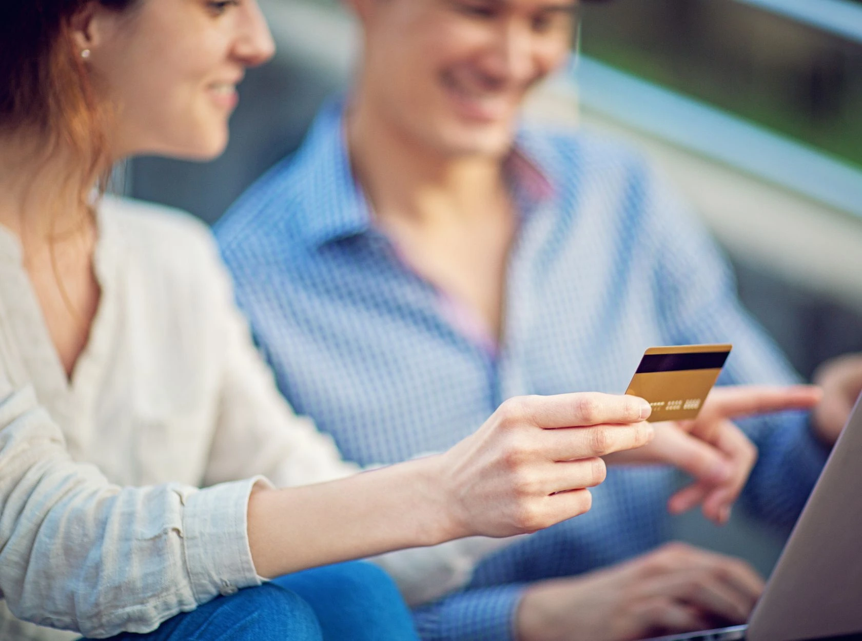 Clients réglant un achat en ligne par carte bancaire sur un ordinateur portable