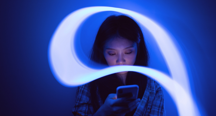Personne utilisant un smartphone, entourée d’un flux lumineux bleu illustrant la continuité du parcours numérique.