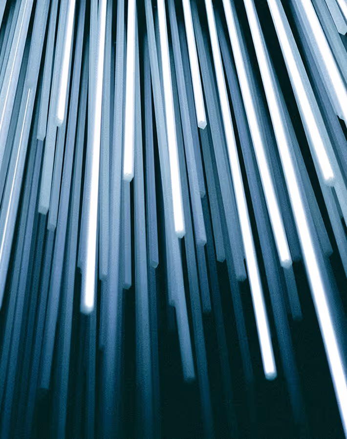 Barres lumineuses blanches suspendues verticalement formant un motif moderne et abstrait.