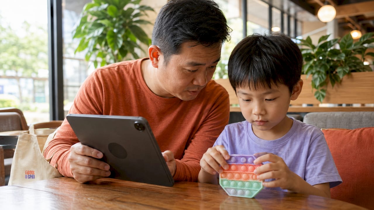Father using tablet with child in library setting