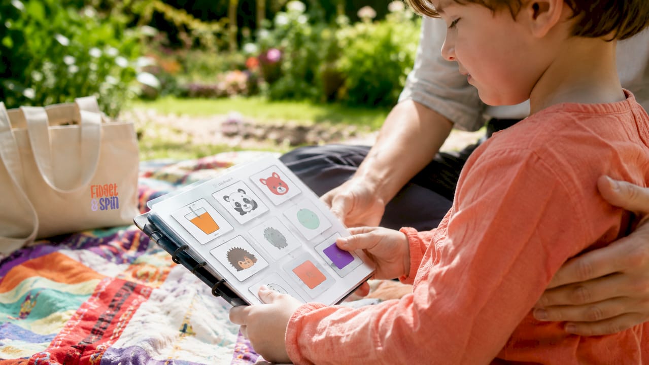 Child and therapist using PECS communication book