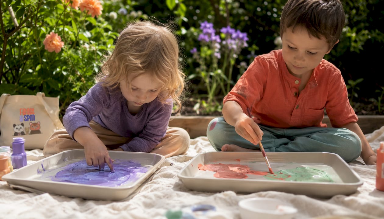 Two children painting side by side quietly