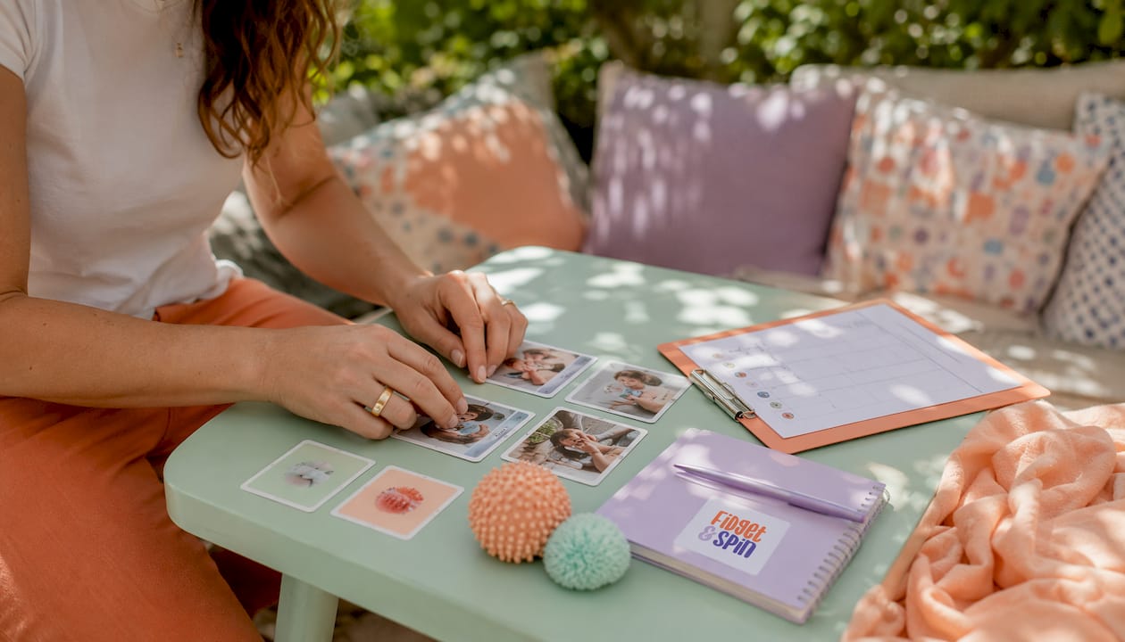 Hands arranging tactile visual supports on table