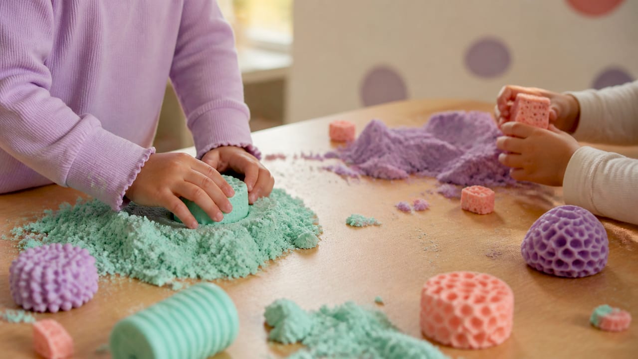 Hands exploring tactile sensory play materials