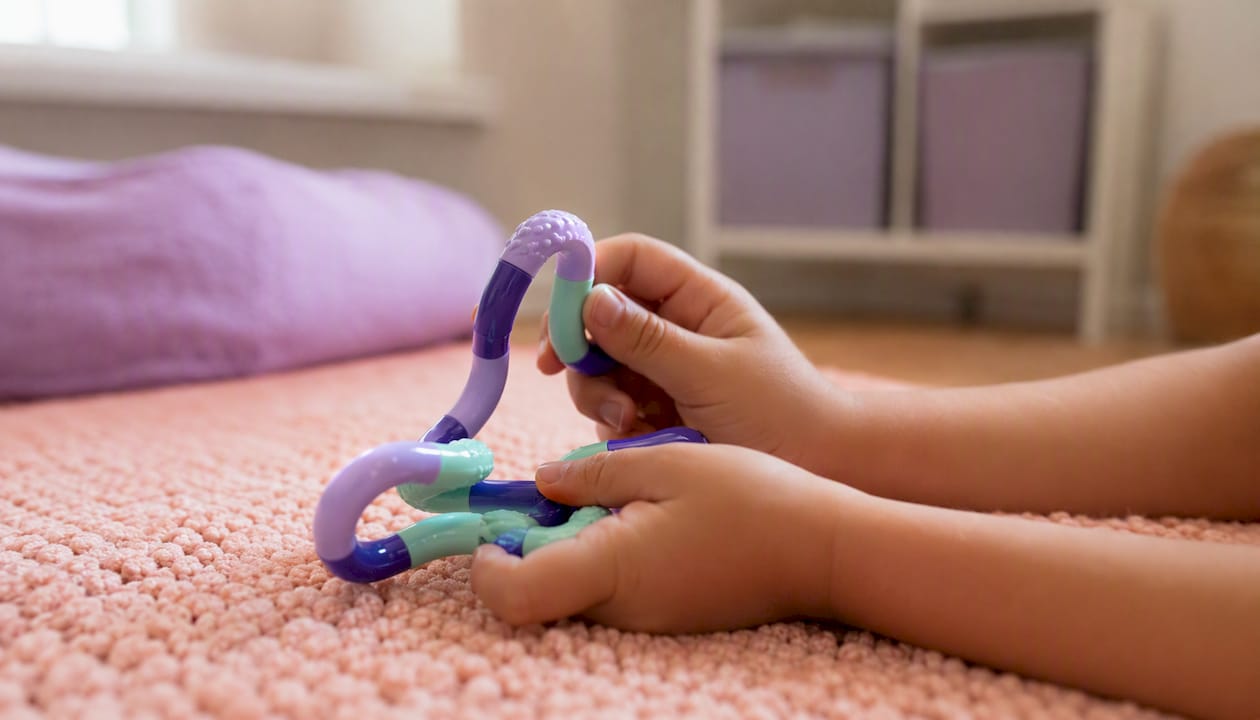 Child hands twisting a Tangle toy