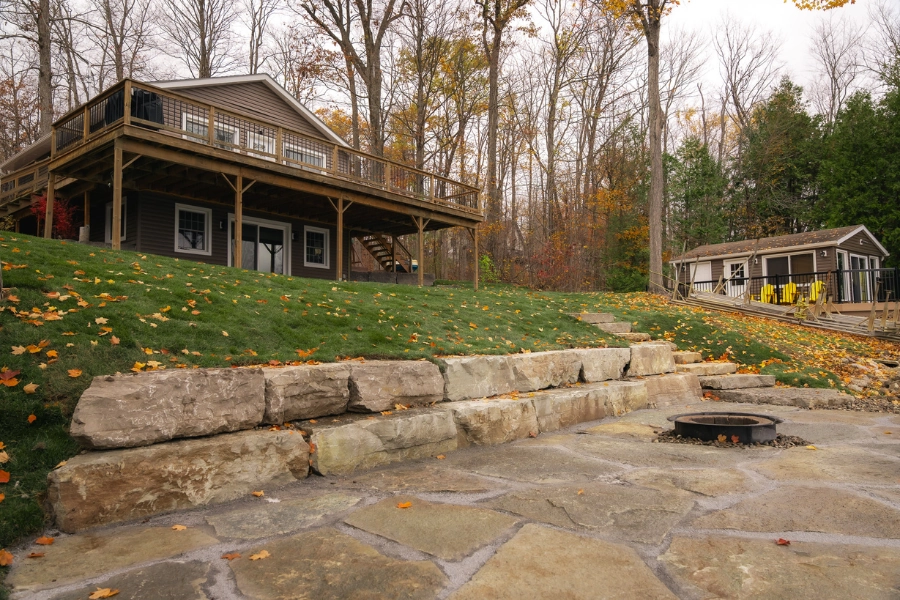 Natural stone retaining wall and paver patio at a Kawartha Lakes shoreline property by TEG Contracting