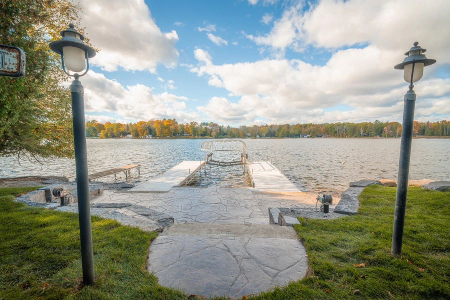 Natural stone shoreline patio leading to a dock on a Kawartha Lakes waterfront by TEG Contracting