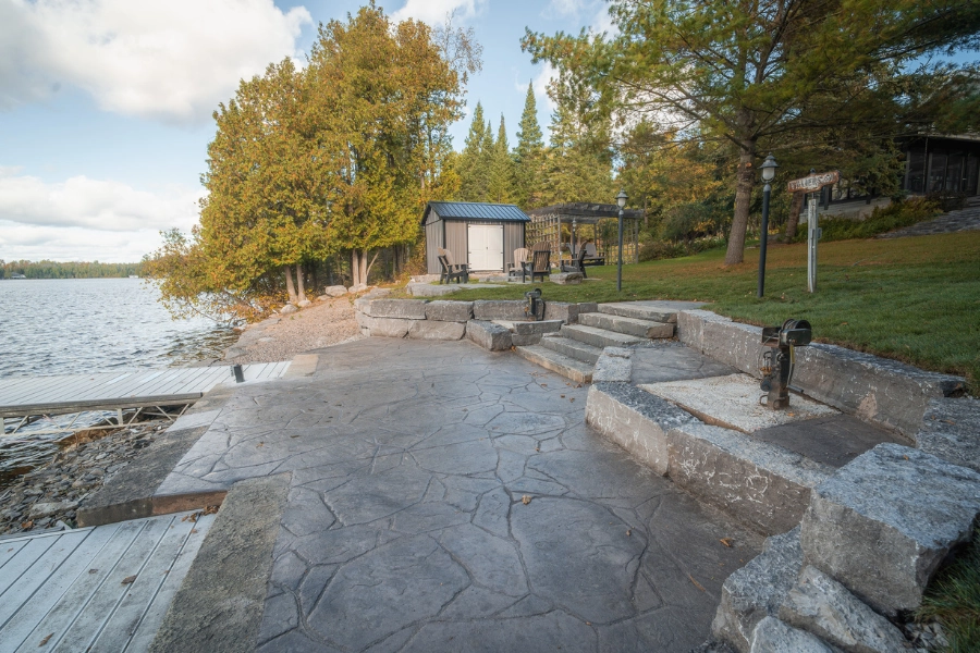 Large natural stone patio and steps at a Kawartha Lakes shoreline property by TEG Contracting