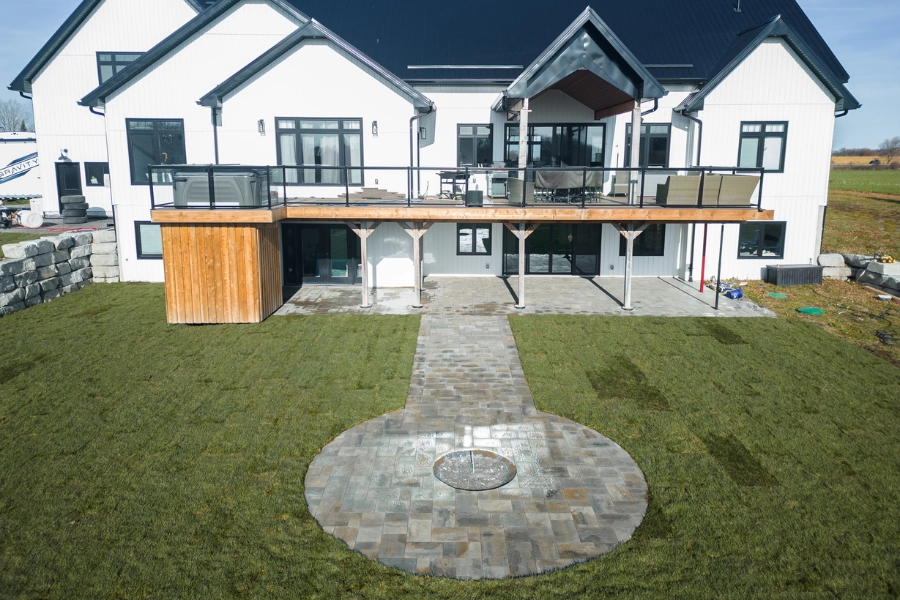 Natural stone circular patio feature and interlocking paver walkway at a Kawartha Lakes home by TEG Contracting