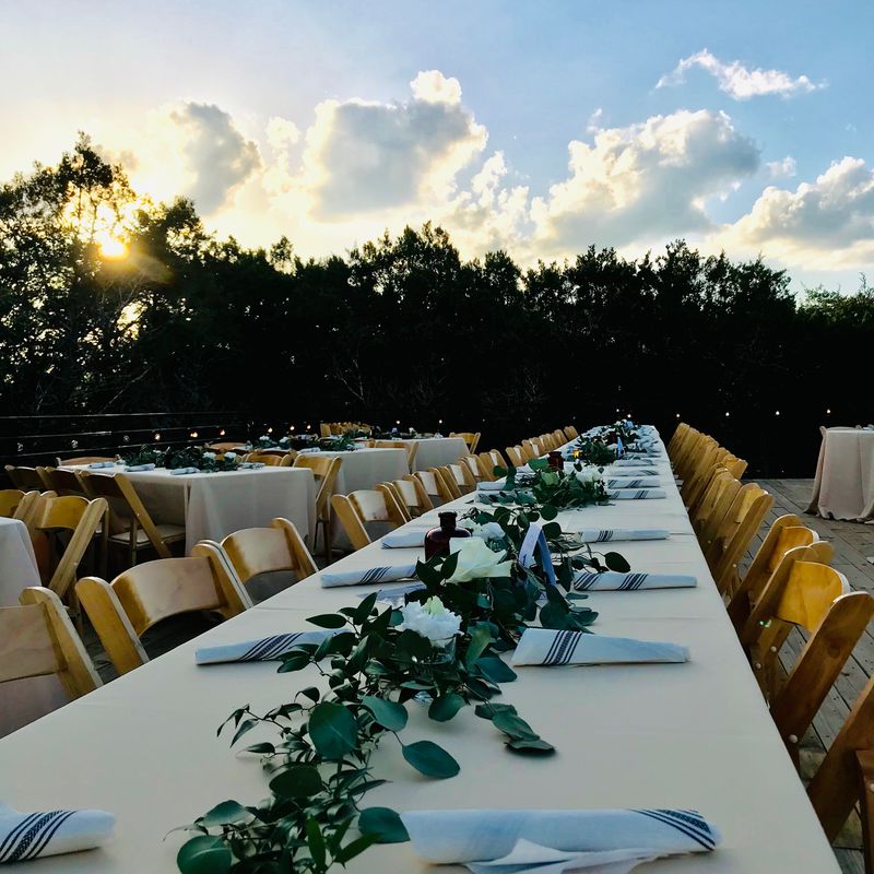 A long banquet table set outdoors at Lucky Arrow Springs at sunset