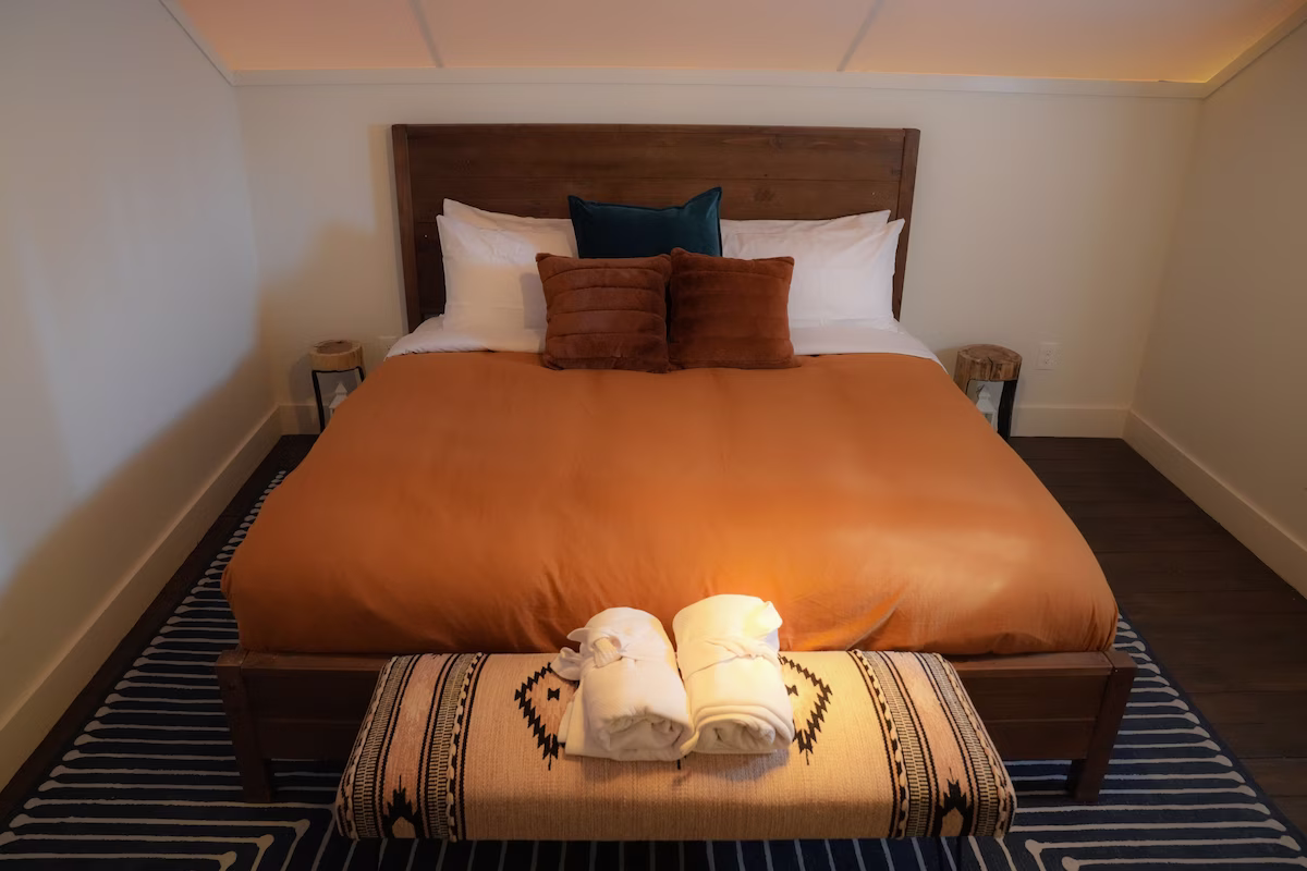 A guest room at Lucky Arrow Springs with robes laid out on the bed