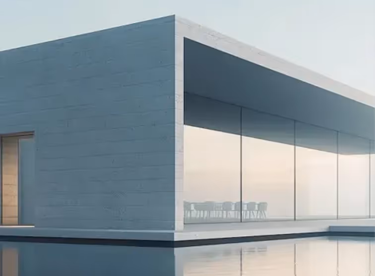 Modern minimalist building with floor-to-ceiling glass walls and a reflecting pool.