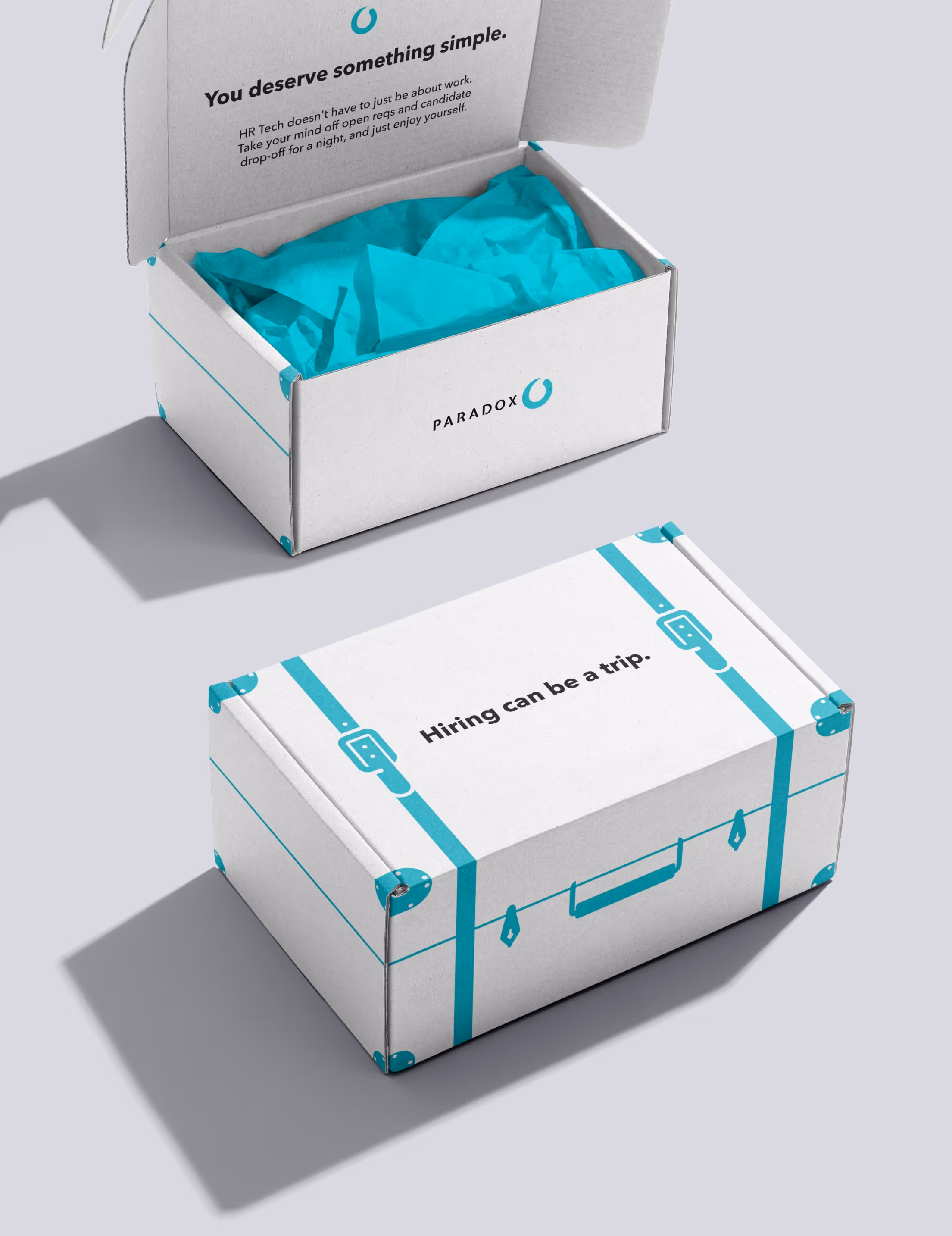 Paradox-branded packaging: an open white box lined with teal tissue reading "You deserve something simple." beside a white suitcase-style box reading "Hiring can be a trip."