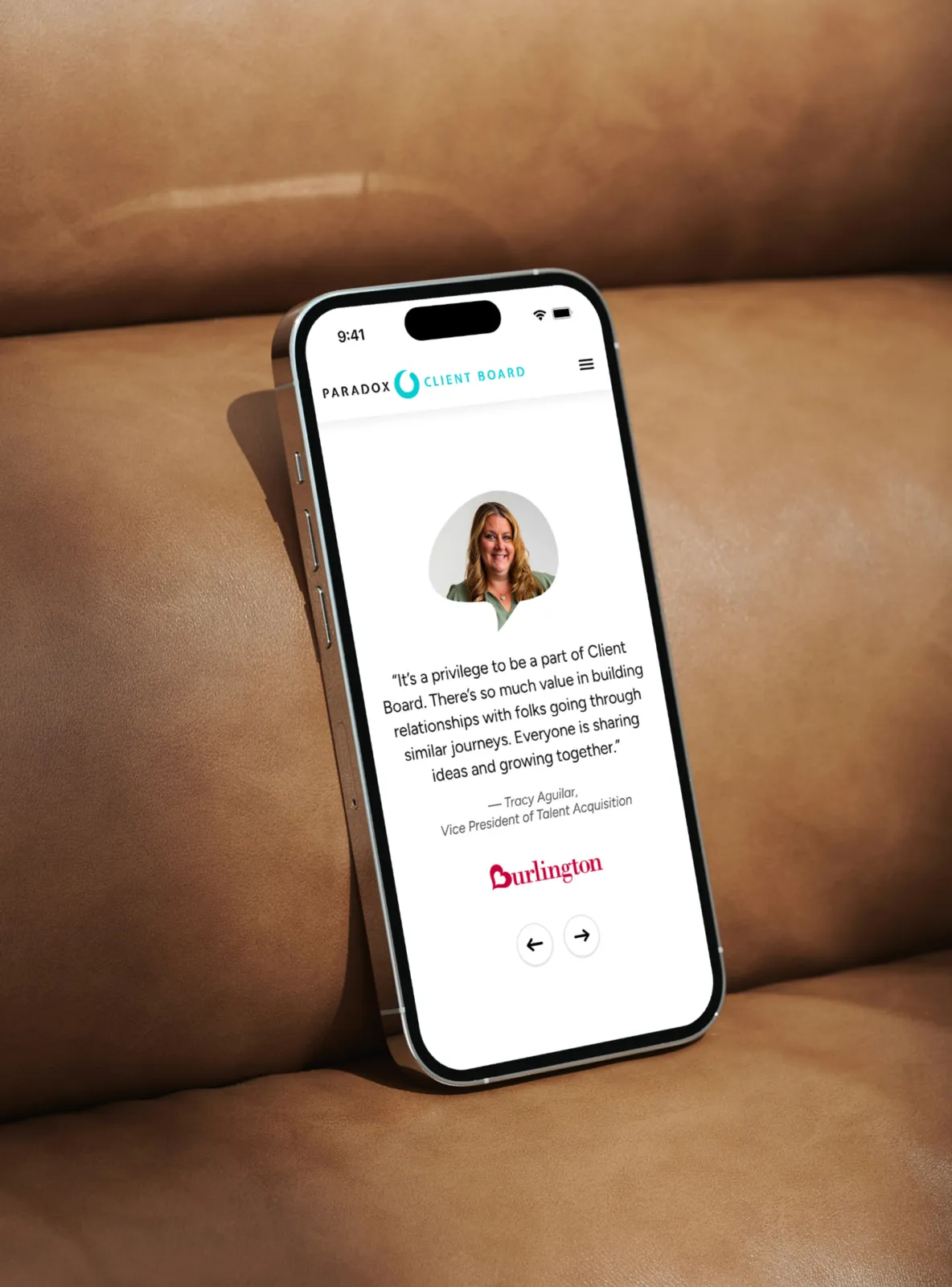 Smartphone on brown couch showing testimonial from Tracy Aguilar, VP of Talent Acquisition at Burlington.