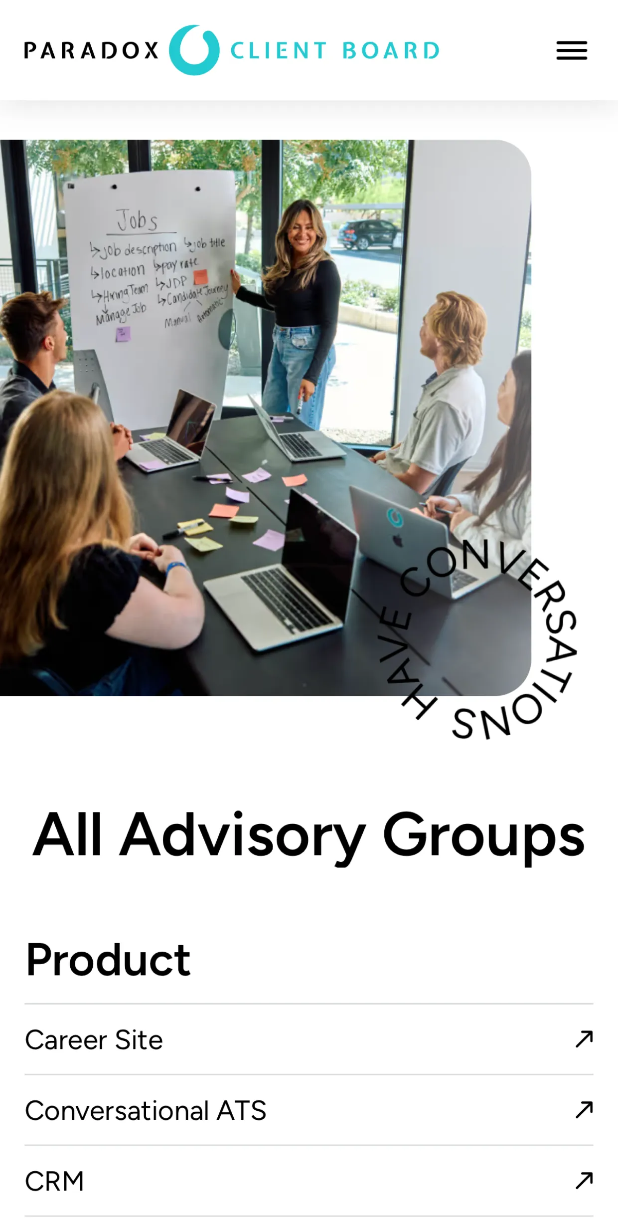 Woman presenting jobs list on whiteboard to four colleagues around table with laptops and sticky notes.