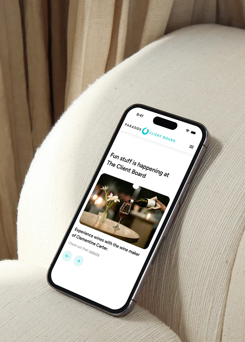 Smartphone on a white chair showing a website about wine tasting with Clementine Carter.