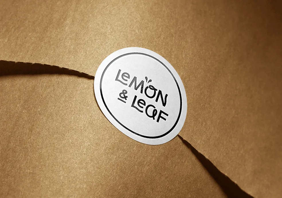 A Lemon & Leaf sticker seal closing a brown paper package.