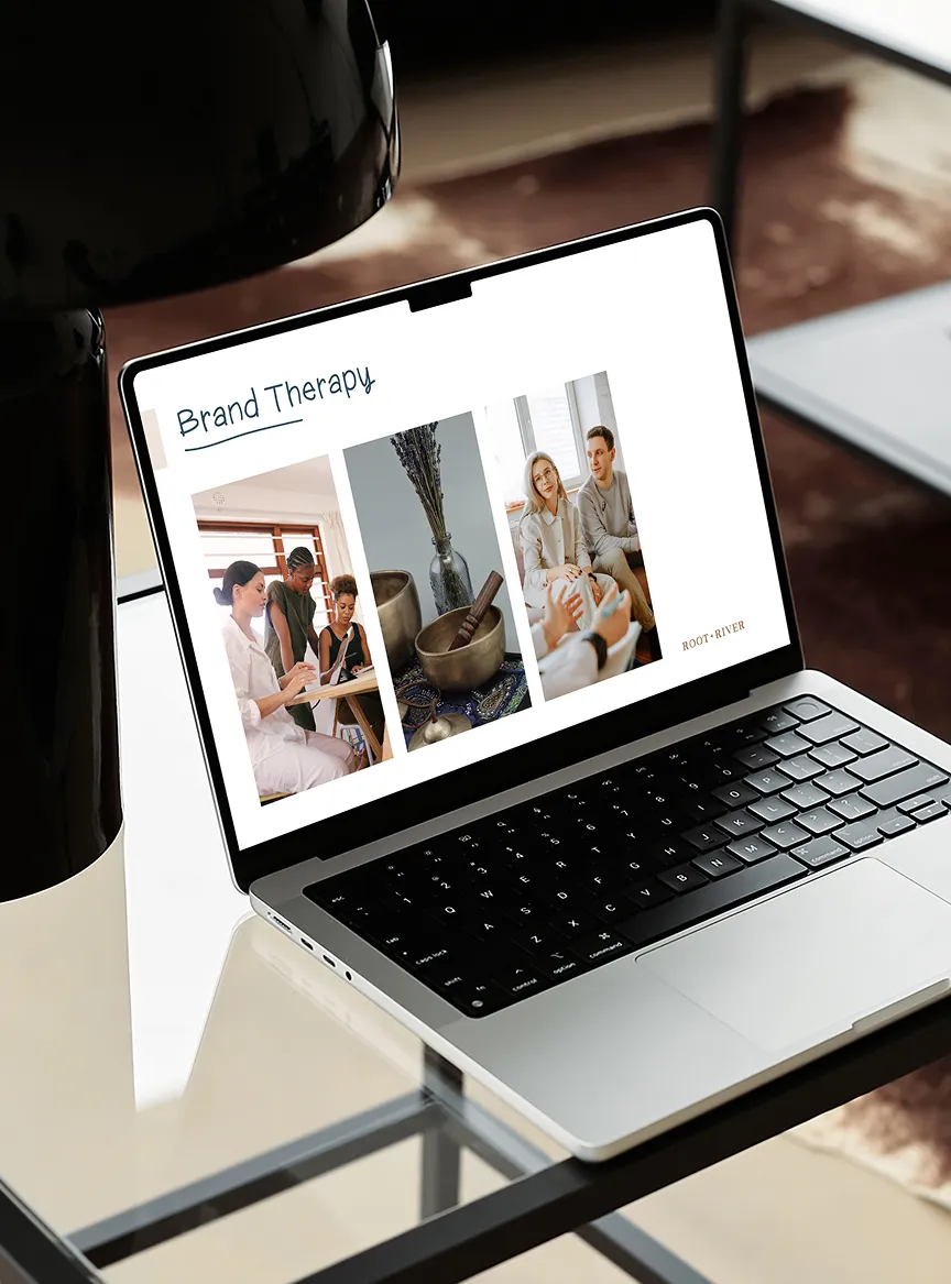 A laptop on a glass table displaying a Root + River Brand Therapy page.