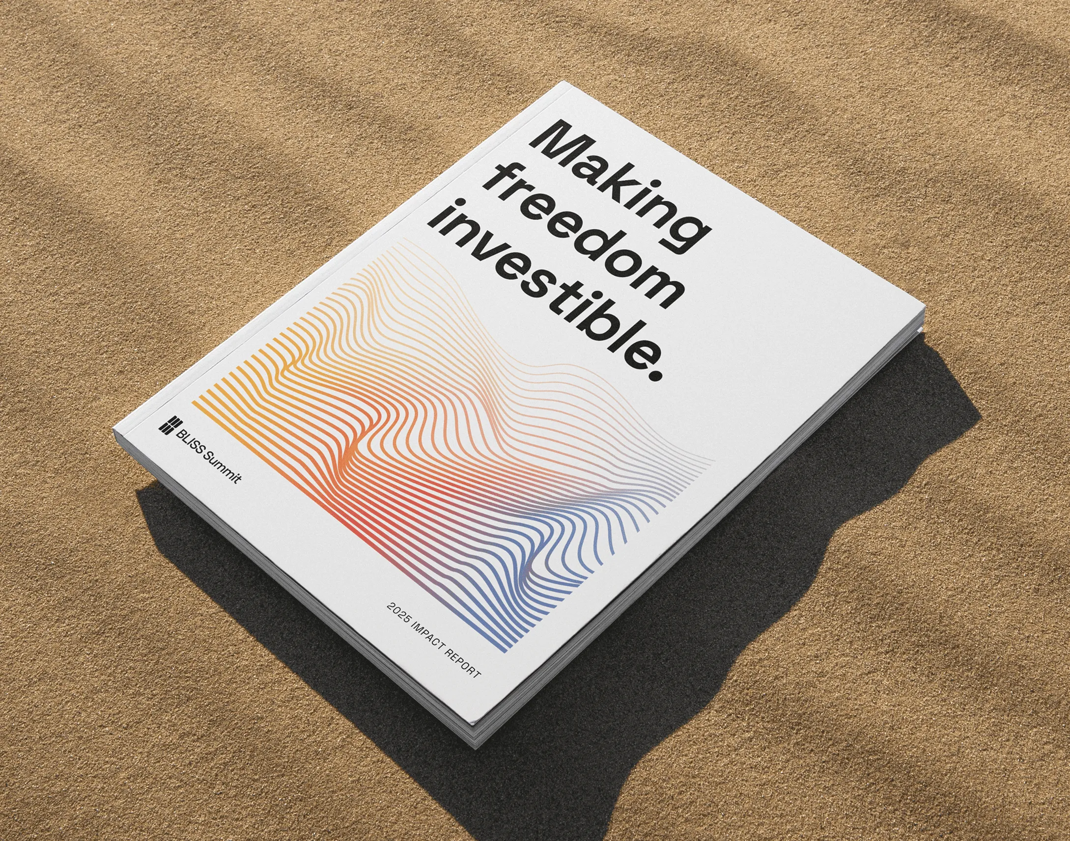 Stack of BLISS Summit 2025 Impact Report booklets on sand with text 'Making freedom investible.'