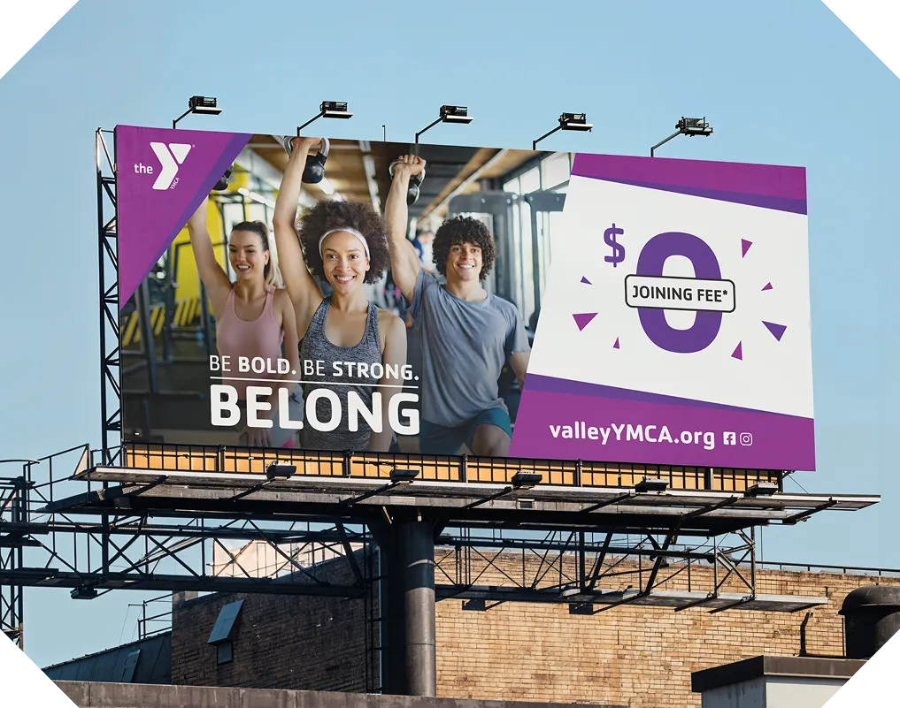 A YMCA billboard reading "Be Bold. Be Strong. Belong." advertising a $0 joining fee.