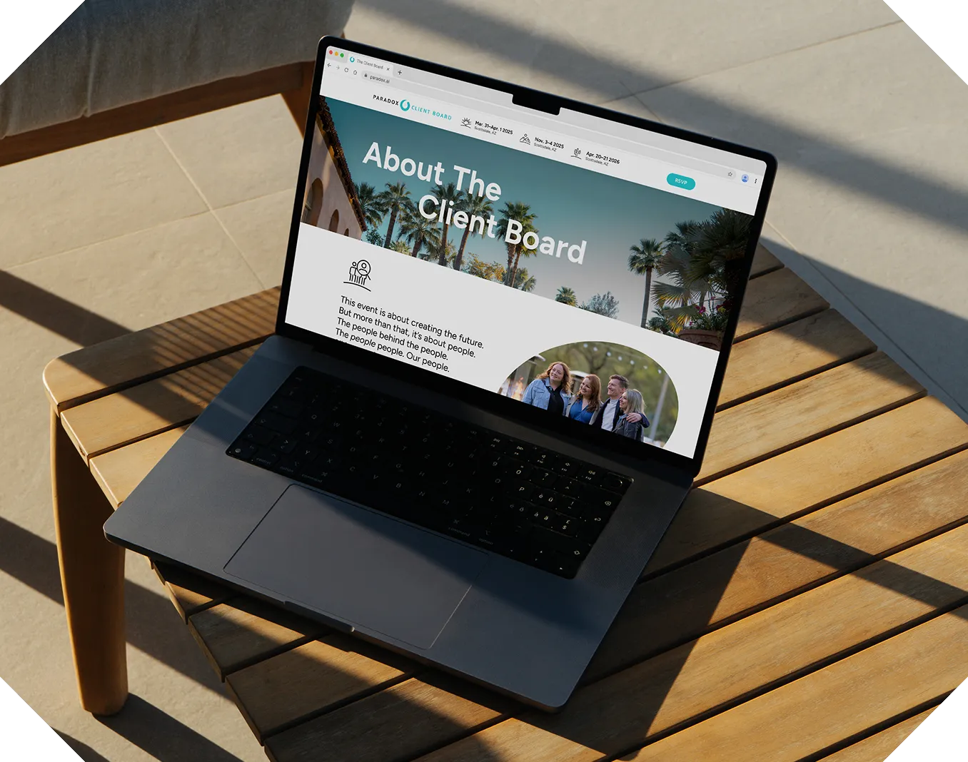 A laptop on a sunlit wooden outdoor table displaying the "About The Client Board" page.