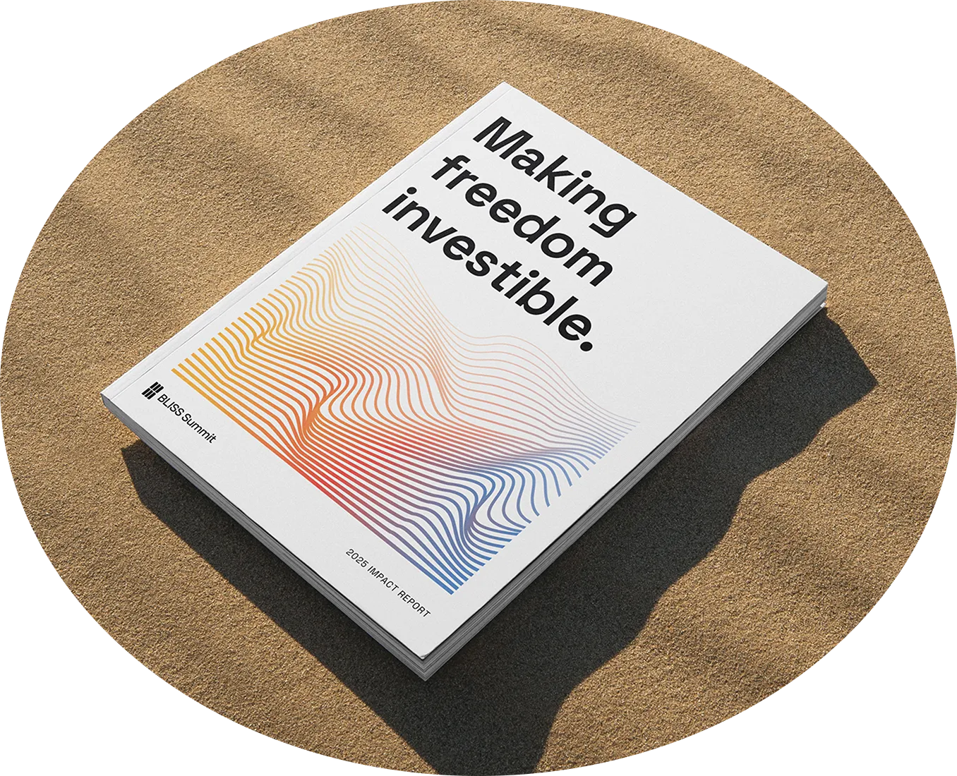 A printed impact report on sand, its cover reading "Making freedom investible."