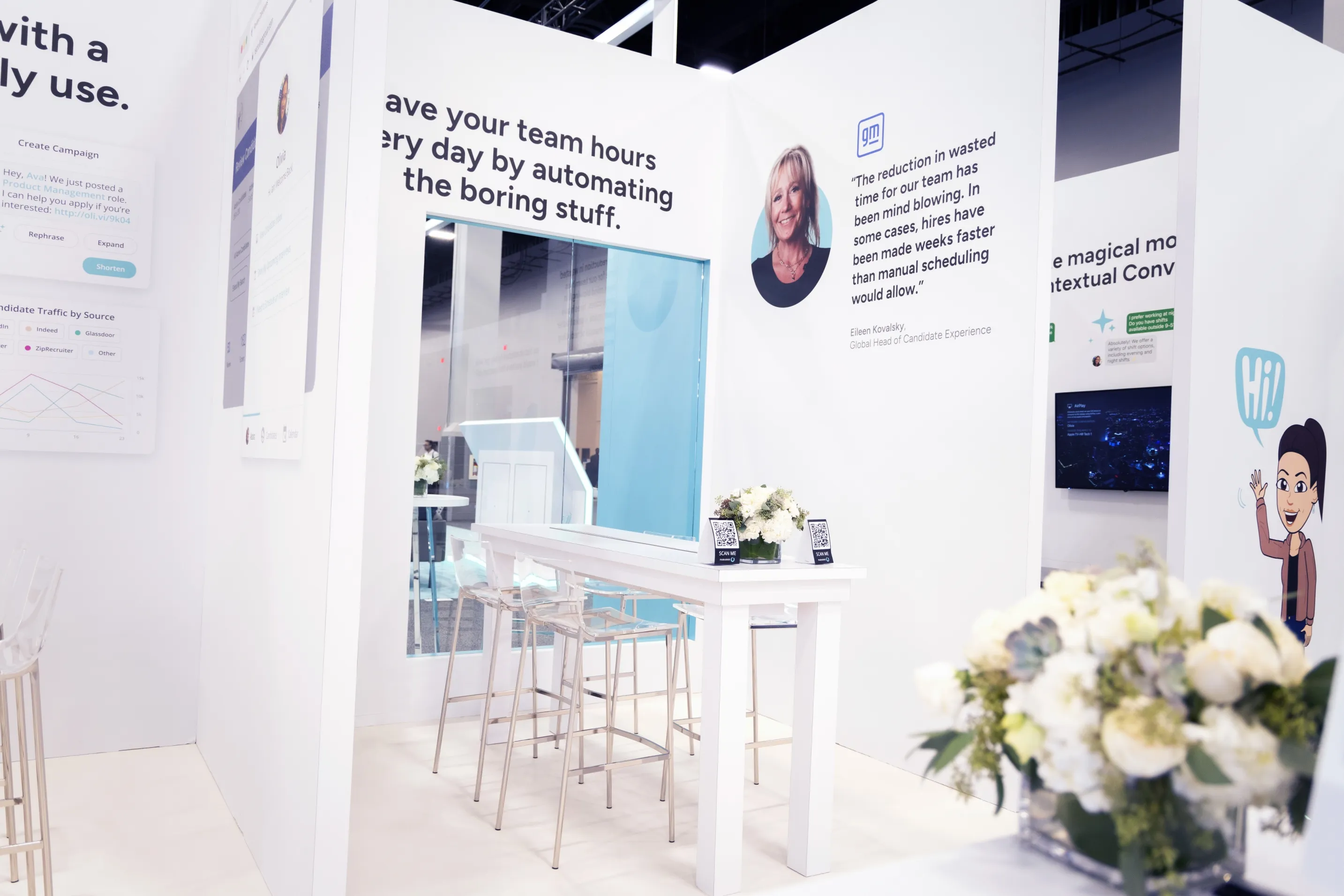 The interior of a Paradox booth with bar stools, floral arrangements and printed panels.