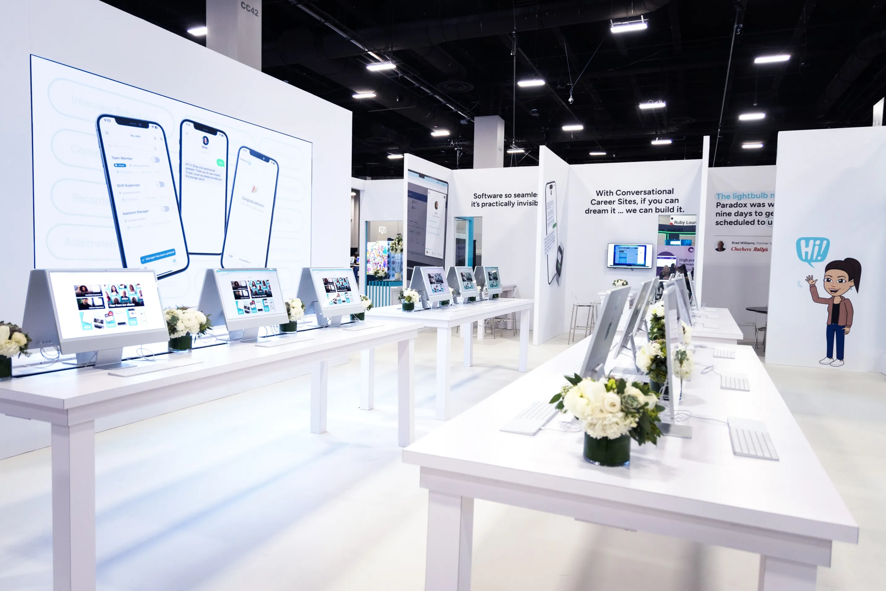 A long white demo counter lined with monitors inside a Paradox exhibition stand.