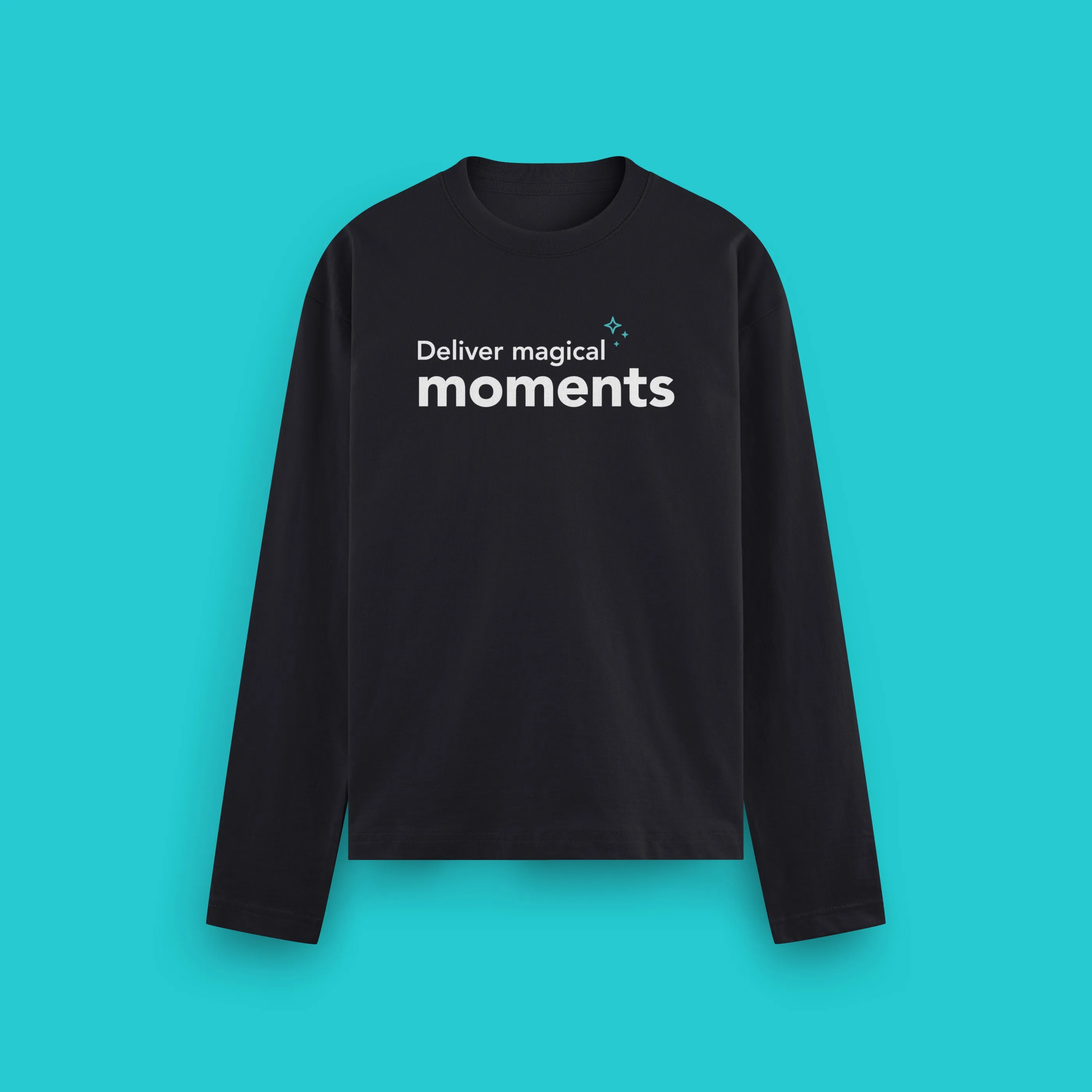 A black long-sleeved Paradox t-shirt printed with "Deliver magical moments" on a teal background.