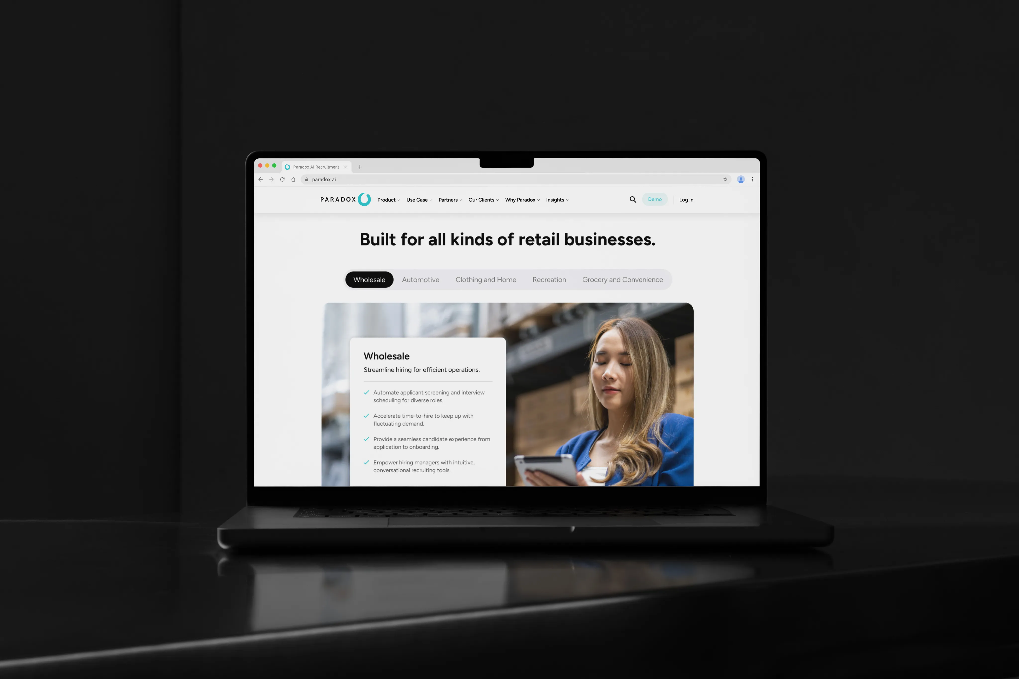 A laptop in a dark room displaying a Paradox page headlined "Built for all kinds of retail businesses."