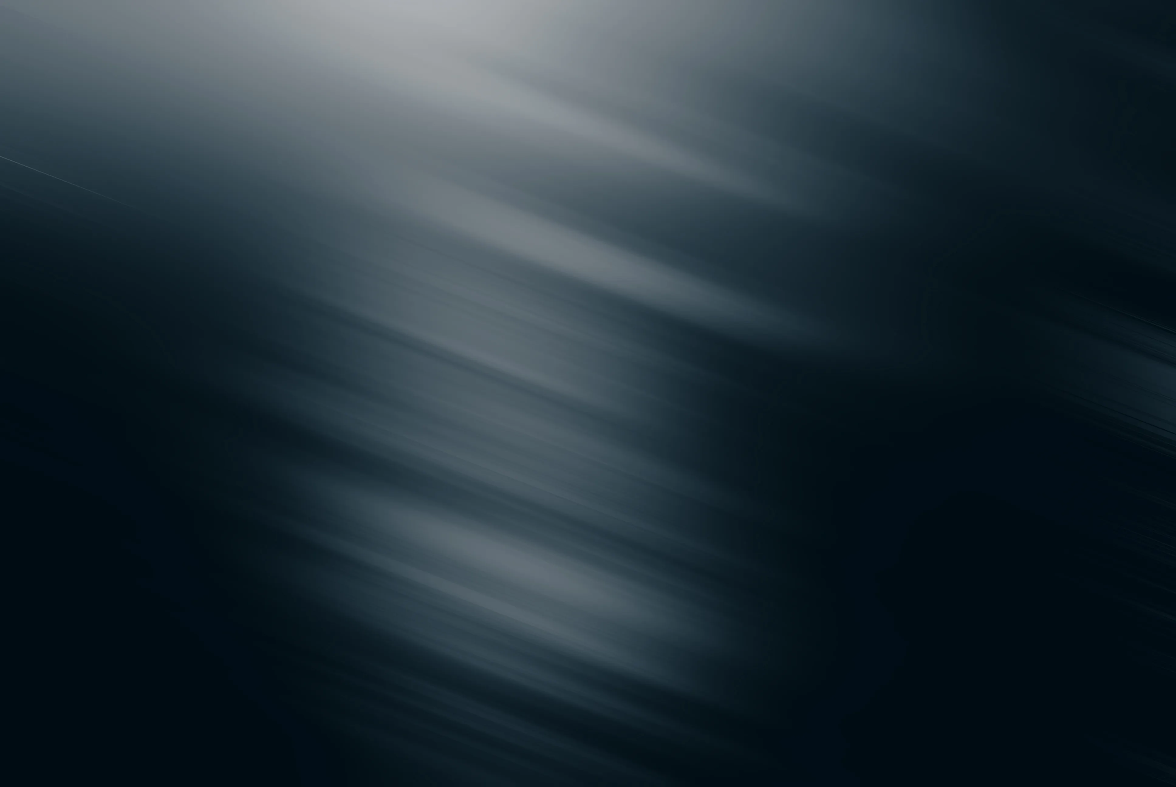 A dark abstract background with soft diagonal light streaks.