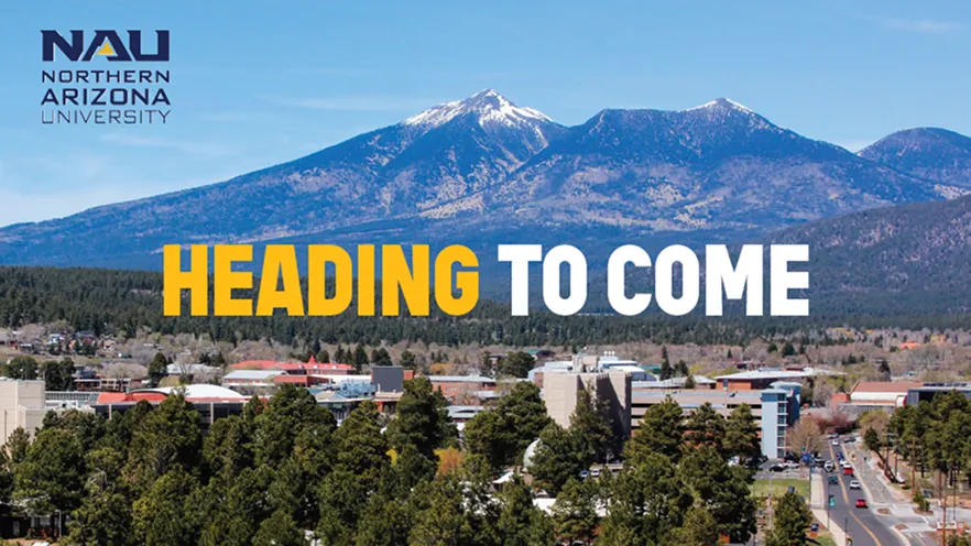 The NAU campus among pine trees, with snow-capped mountains beyond.